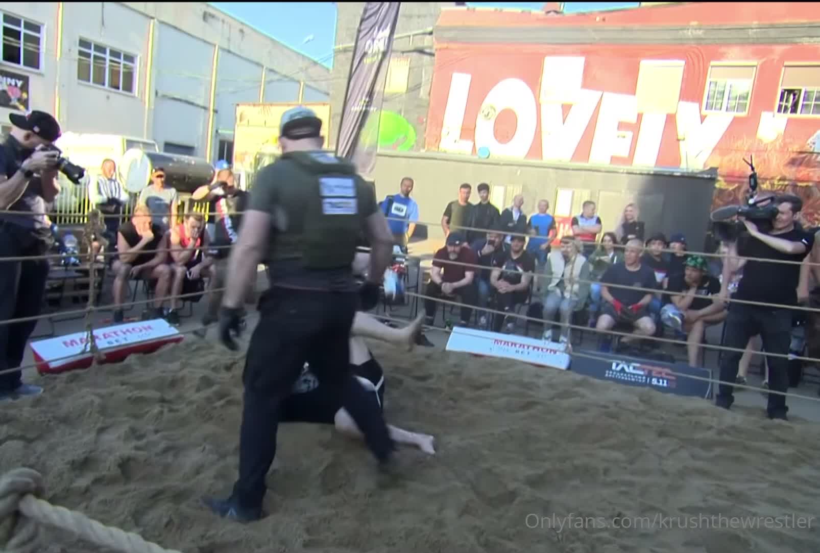 Russian dudes have rough fight in a sand ring.